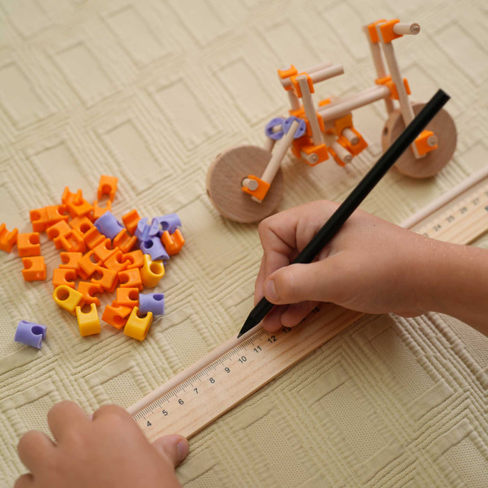 Child measuring Beaver real wood pieces before building