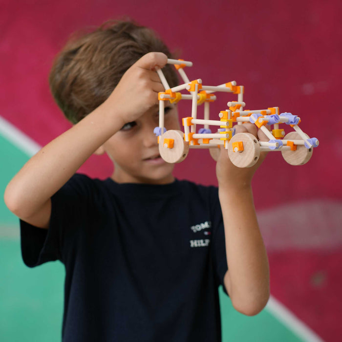Child holding a vehicle made with Beaver wooden pieces